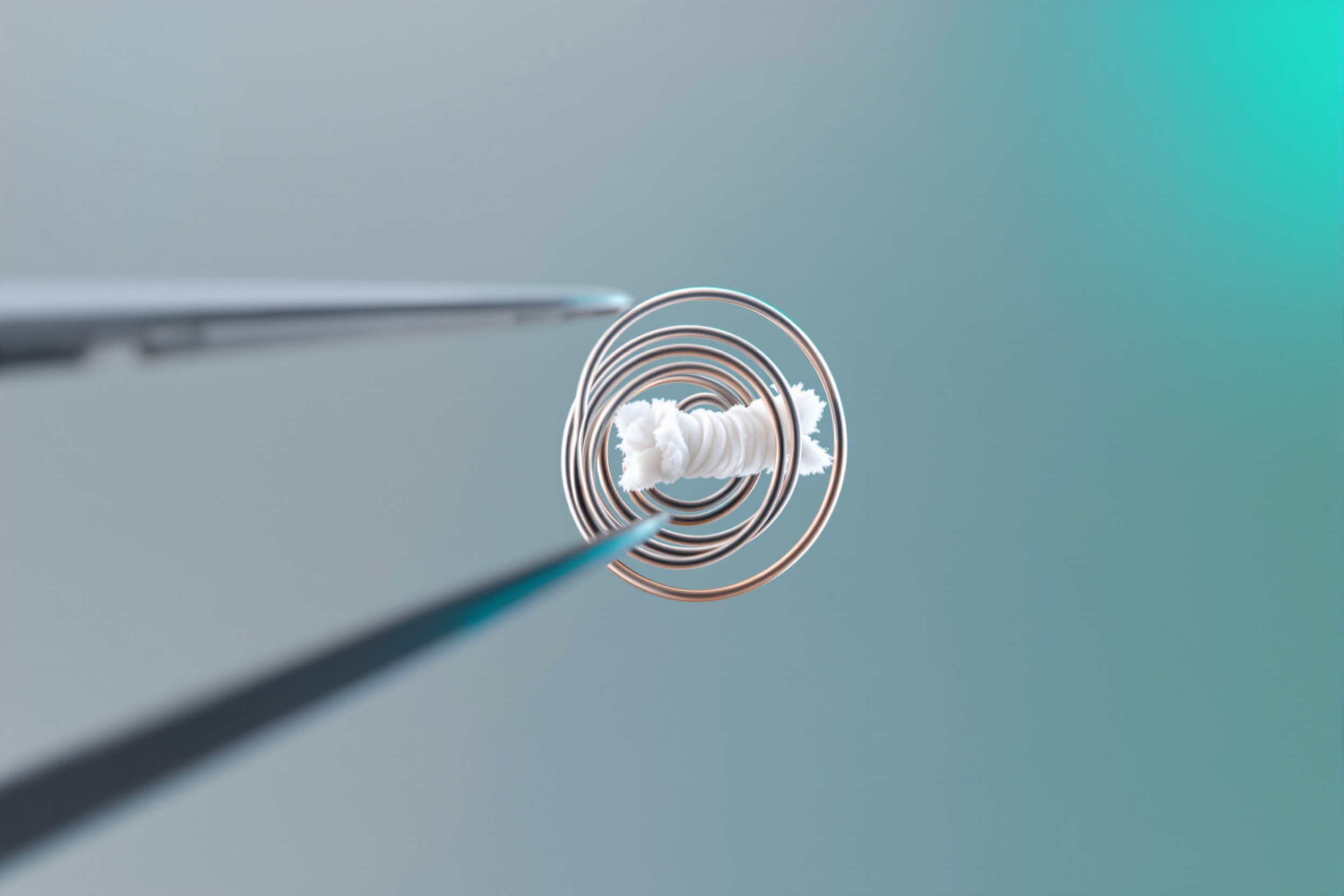 Close-up of a vaping atomiser coil and cotton wick held in tweezers
